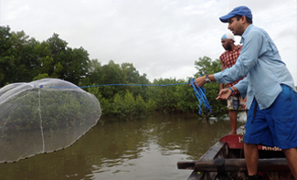 Prosanta Chakrabarty in a boat casting a net into the water