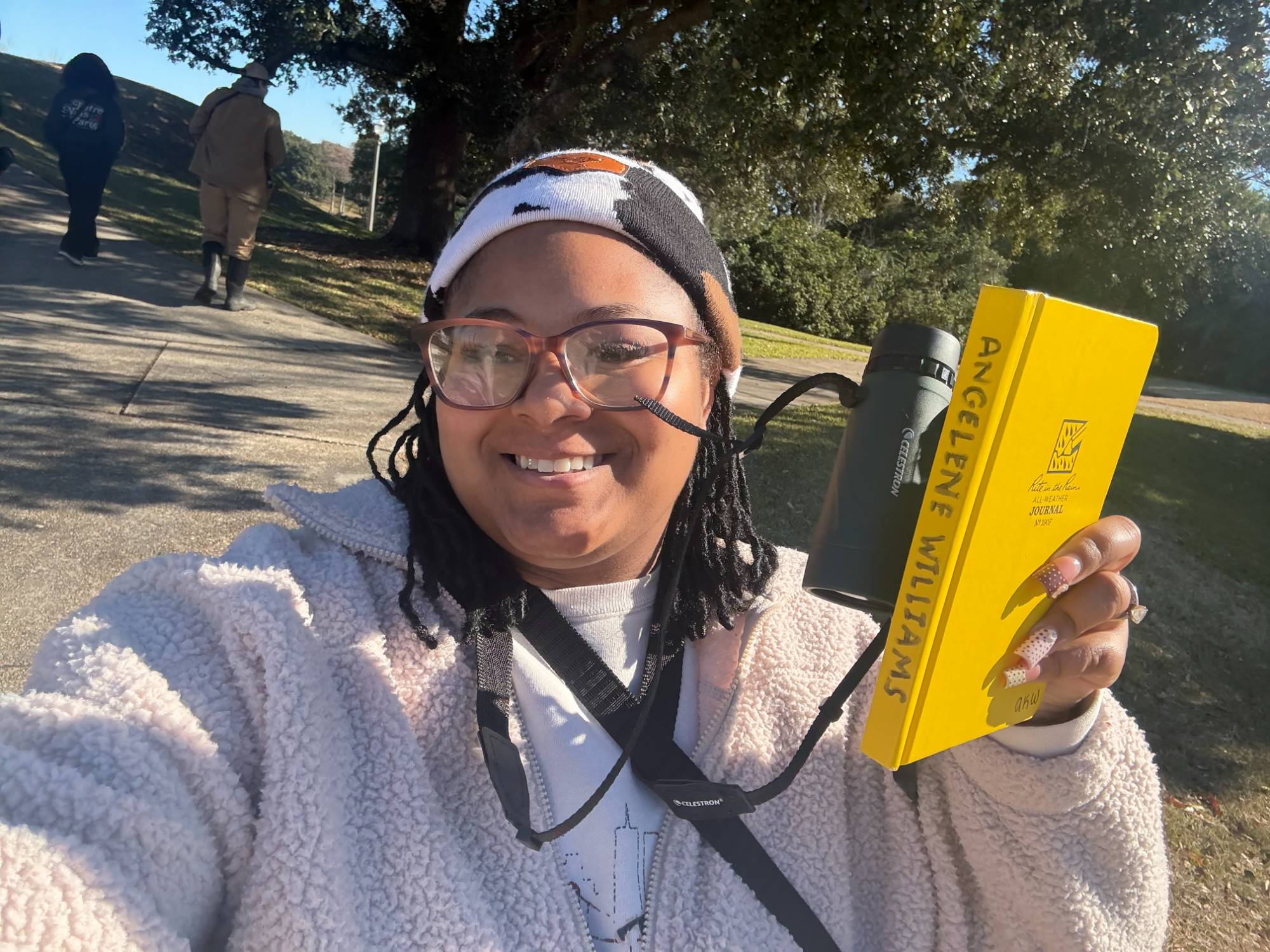 Angelene Williams with binoculars and a notebook