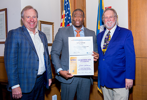 CAEP graduate LeVar Anderson holds his completion certificate in this photo taken at the program's graduation ceremony. On the right side of the photo is program director Brian Andrews.