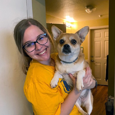 Emily poses with a dog. 